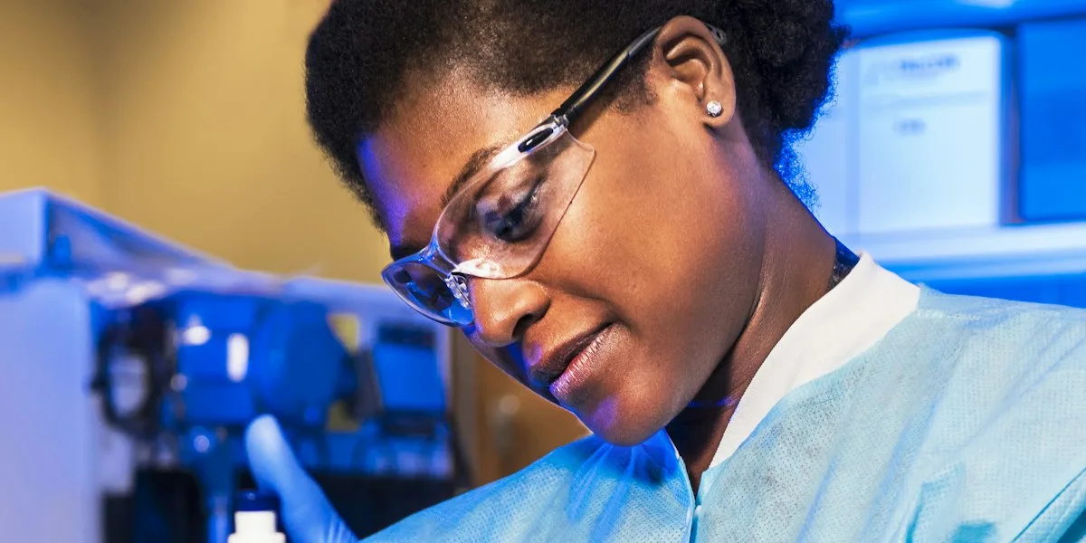A scientist in safety glasses working in a laboratory